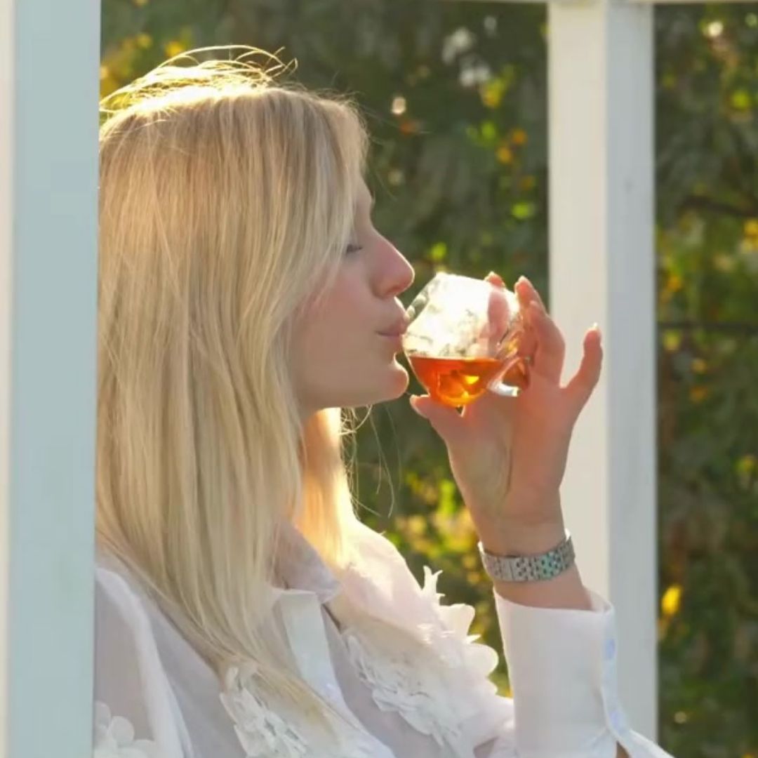 Woman enjoying a pour from the EQUILO No.1 glass — designed for spirits like whiskey and rum.