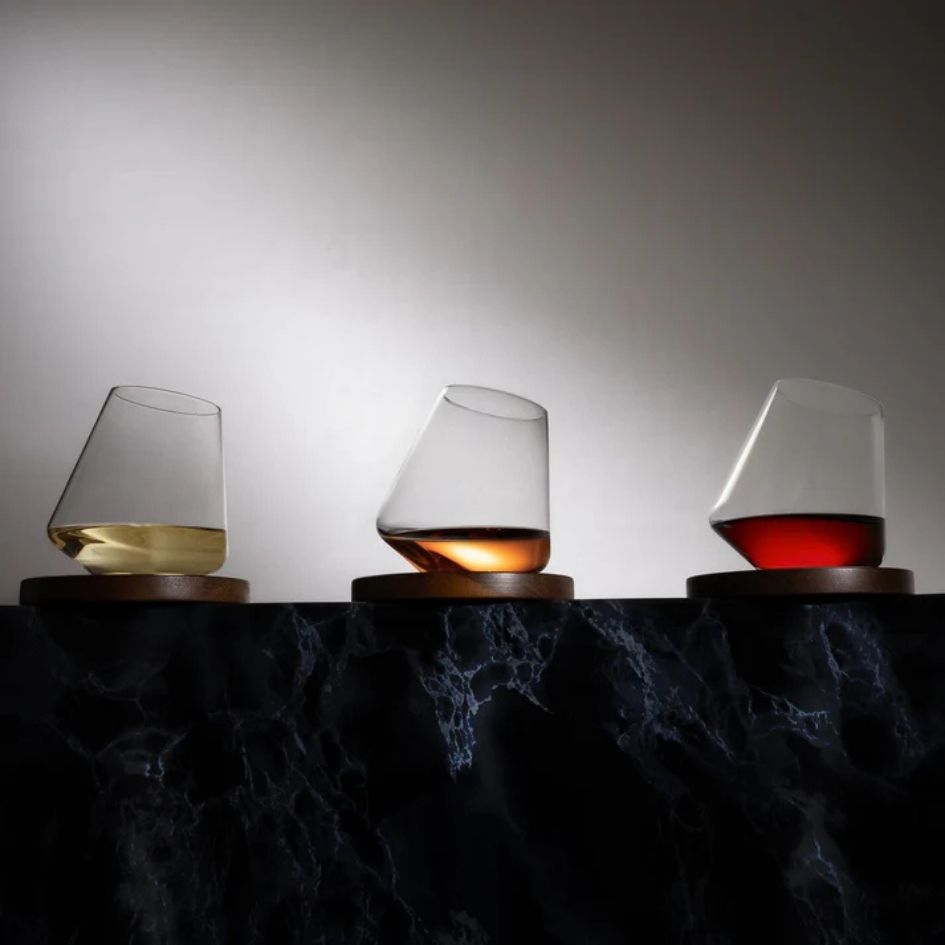 EQUILO No.3 glasses with white, amber, and red drinks on dark marble surface